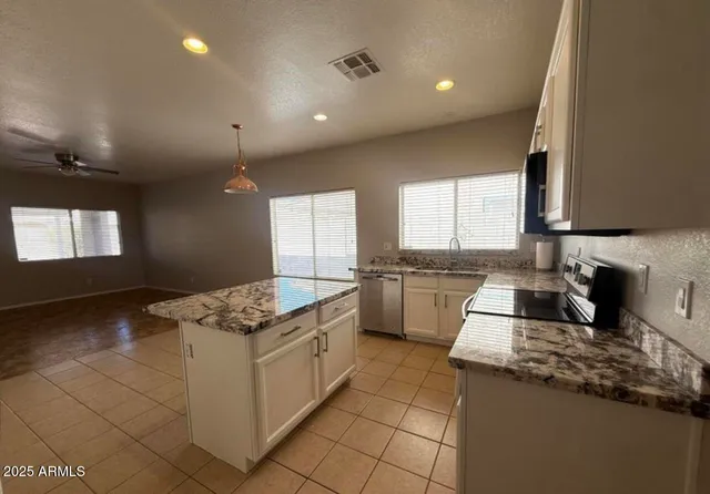 a kitchen with a stove a sink a refrigerator and window