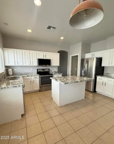 a large kitchen with cabinets and stainless steel appliances