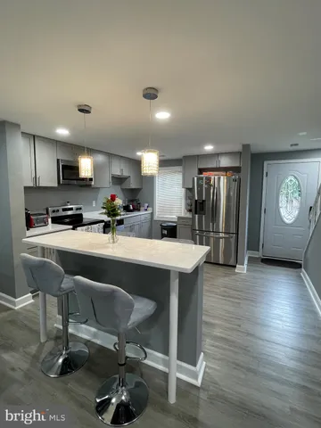 a kitchen with a table chairs refrigerator and microwave