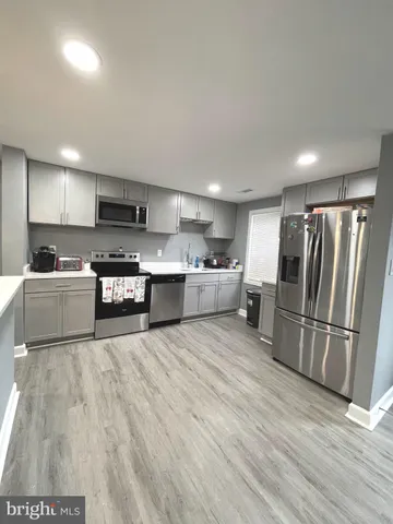 a large kitchen with stainless steel appliances granite countertop a stove a sink and a refrigerator