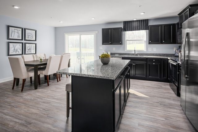 a kitchen with kitchen island granite countertop a sink cabinets and stainless steel appliances