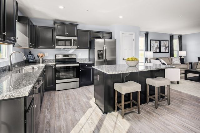 a kitchen with stainless steel appliances a stove sink microwave and refrigerator