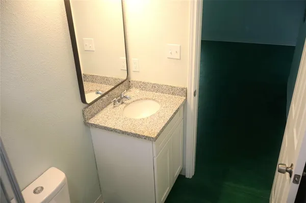 a bathroom with a granite countertop sink and a mirror