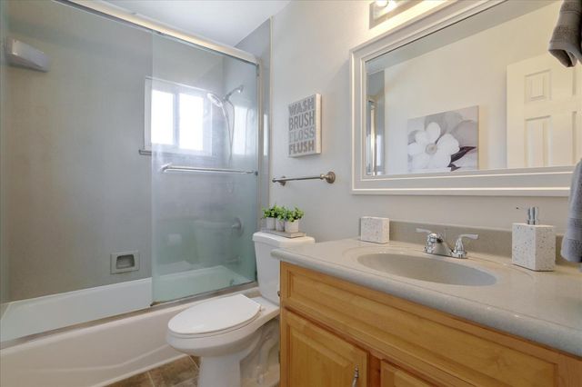 a bathroom with a granite countertop toilet a sink and mirror