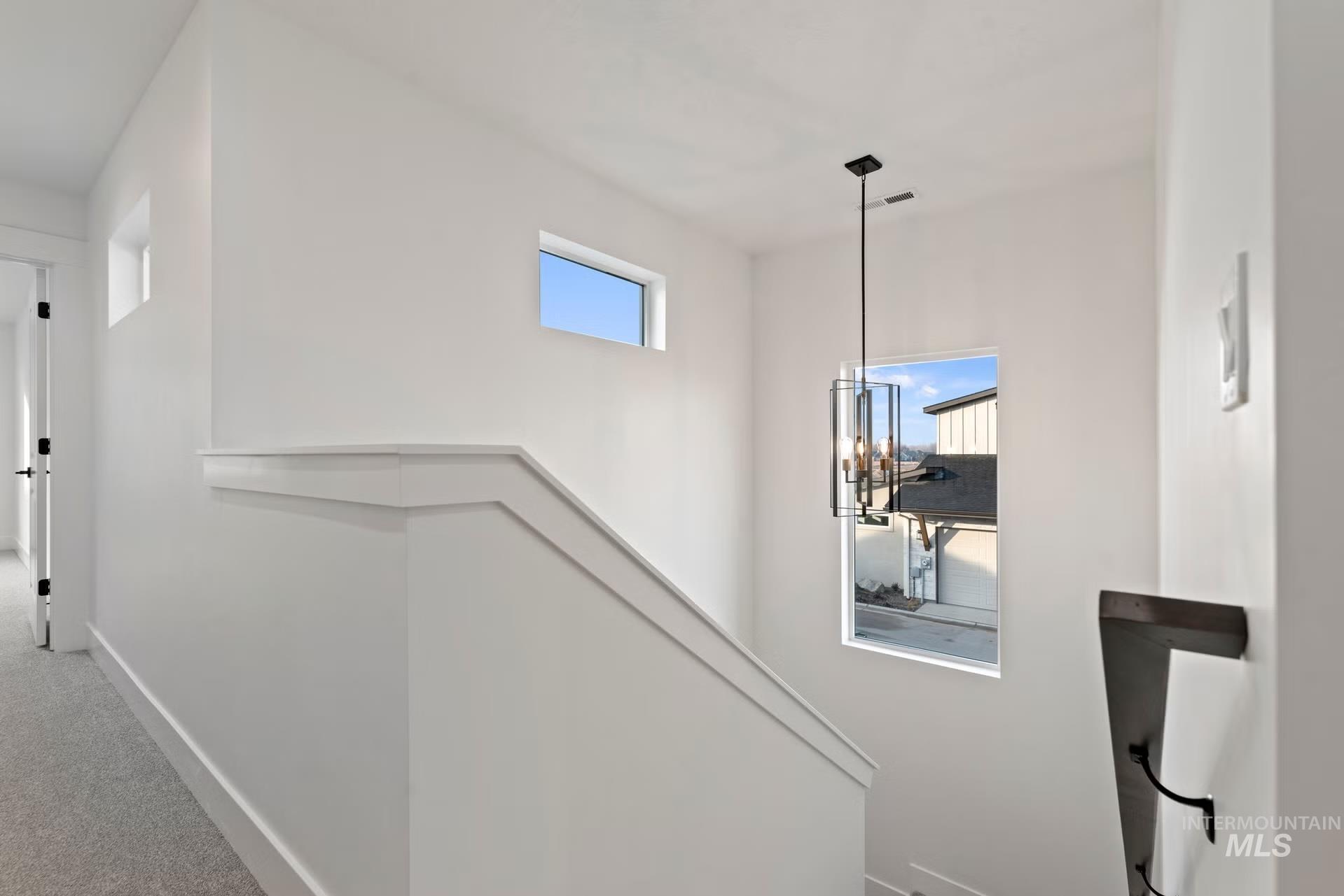 748 South Calhoun Place Star, ID 83669 - Photo 19 of 32 Hallway featuring carpet floors, suspended lighting, and an upstairs landing