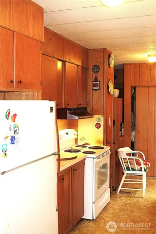 a kitchen with stainless steel appliances a refrigerator a stove a sink and white cabinets