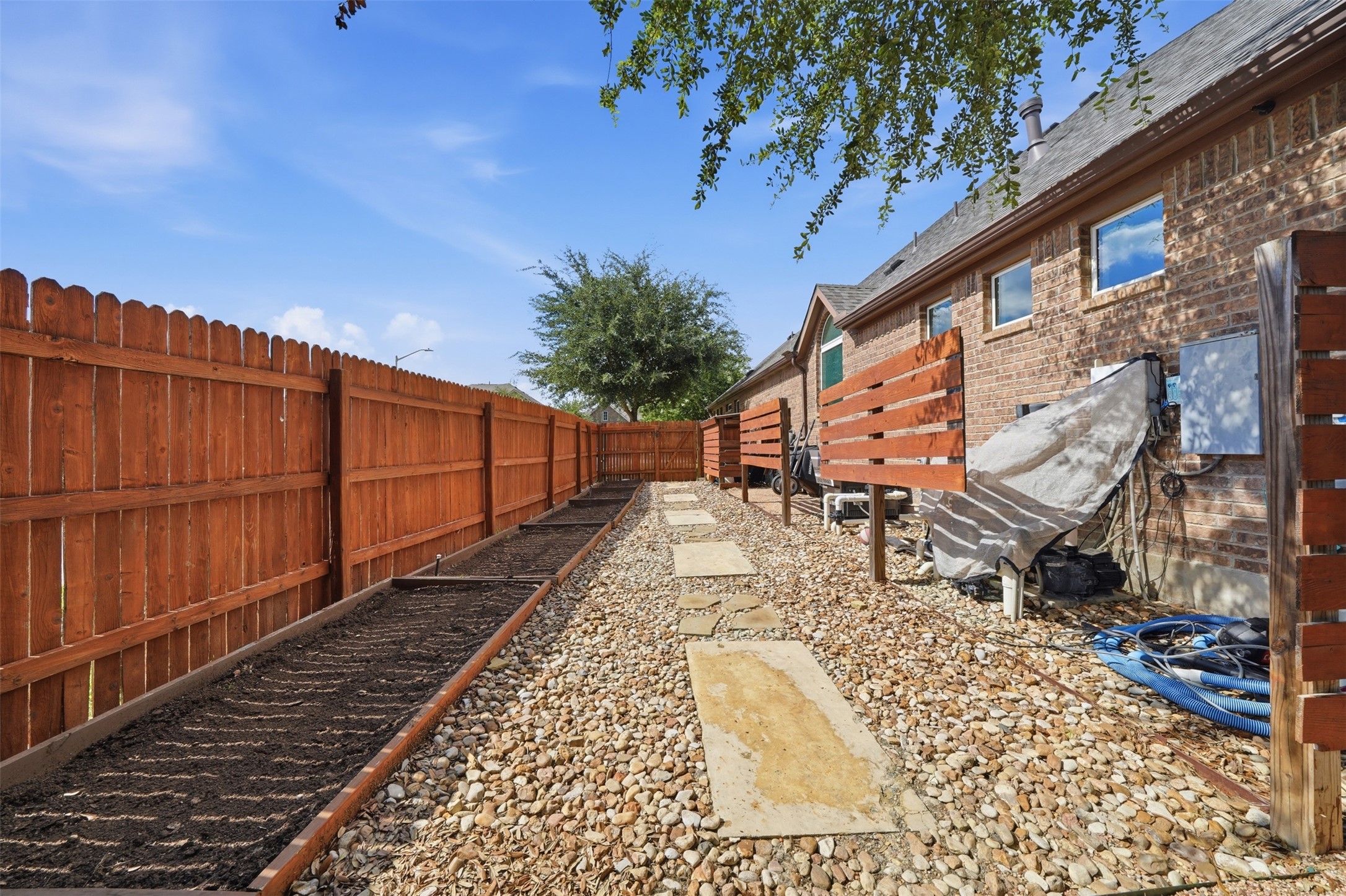 8729 Vantage Point Drive Austin, TX 78737 - Photo 28 of 33 A private backyard oasis features a well-maintained garden bed and charming stepping stones.