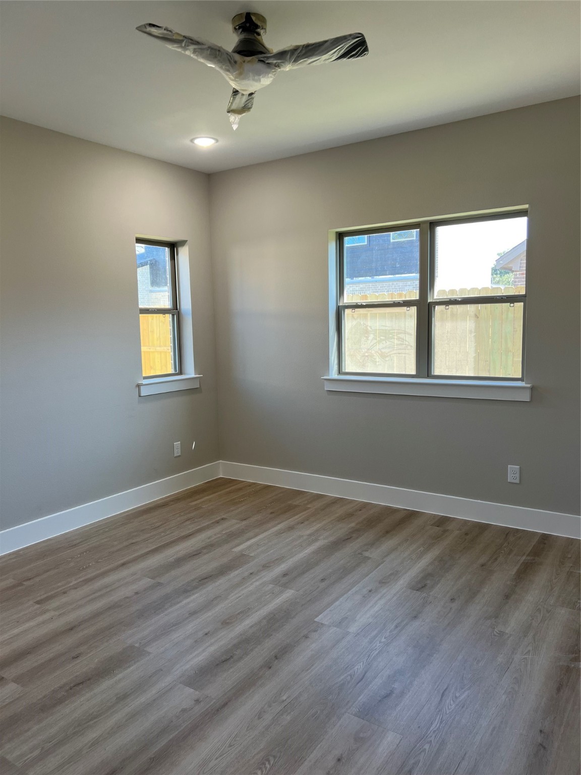 2511 Martinas Ct Spring Spring, TX 77388 - Photo 26 of 30 an empty room with wooden floor ceiling fan and windows