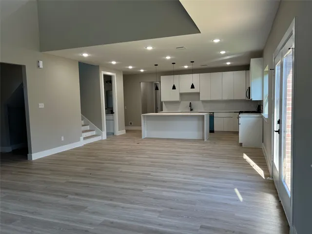 a kitchen with kitchen island granite countertop a sink and cabinets