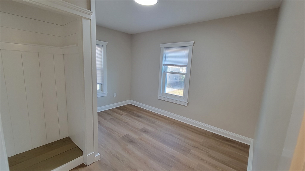 30 O'Neil Street, Unit 2 Hudson, MA 01749 - Photo 16 of 28 an empty room with wooden floor and windows