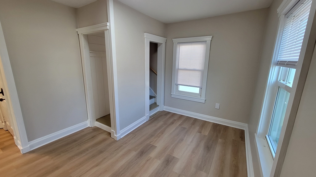 30 O'Neil Street, Unit 2 Hudson, MA 01749 - Photo 17 of 28 an empty room with wooden floor and windows