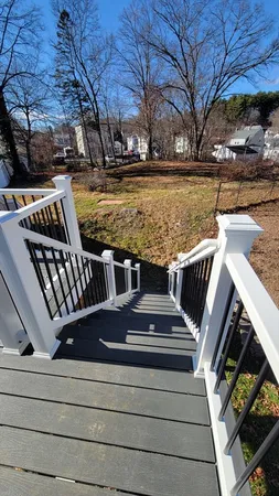 a view of a roof deck with two couches and wooden floor