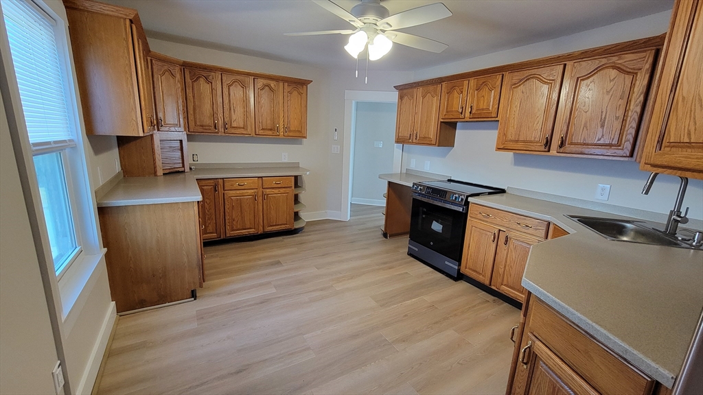 30 O'Neil Street, Unit 2 Hudson, MA 01749 - Photo 6 of 28 a kitchen with stainless steel appliances granite countertop a refrigerator a sink dishwasher a stove and white countertops with wooden floor