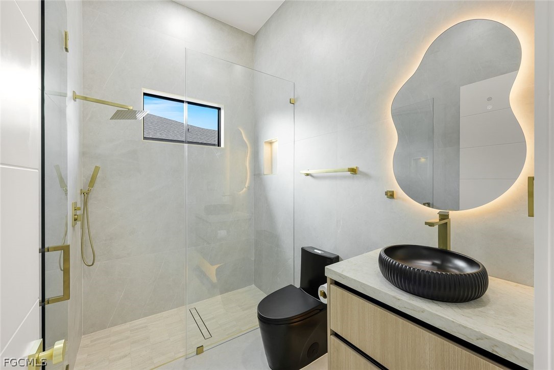 3606 Southwest 3rd Street Cape Coral, FL 33991 - Photo 32 of 47 a bathroom with a sink a toilet and a mirror