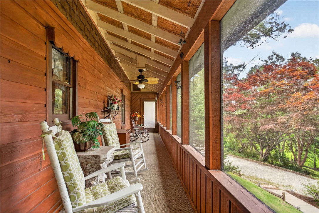 351 River Road Westminster, SC 29693 - Photo 19 of 50 A lengthy screened porch extends along the structure, offering serene views of the surrounding natural landscape.