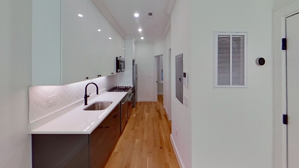 a hallway with sink and mirror