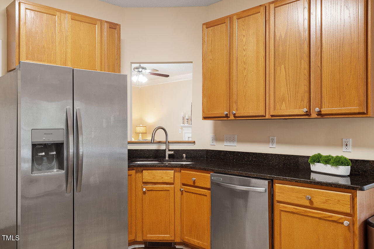 7040 Bellard Court Raleigh, NC 27617 - Photo 13 of 31 a kitchen with stainless steel appliances granite countertop white cabinets and a refrigerator