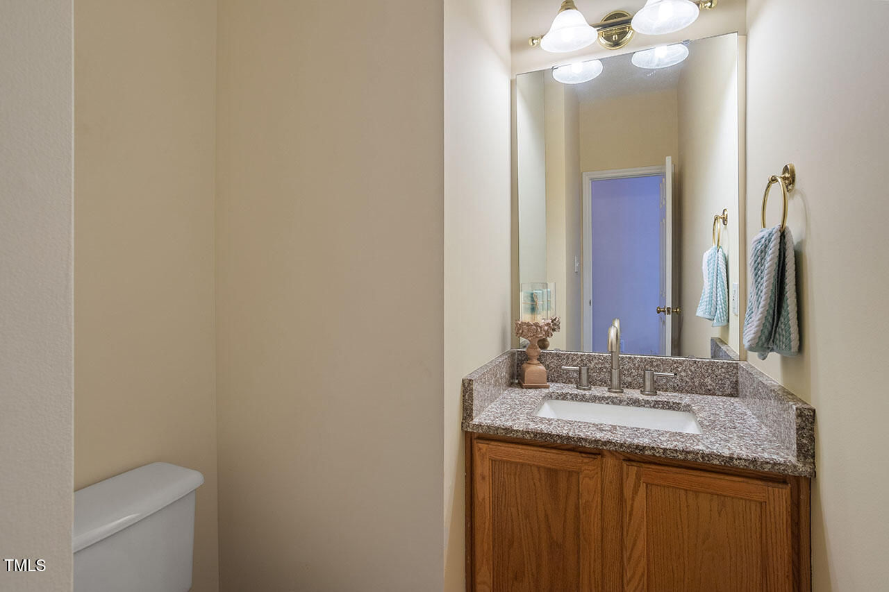 7040 Bellard Court Raleigh, NC 27617 - Photo 16 of 31 a bathroom with a granite countertop sink and a mirror