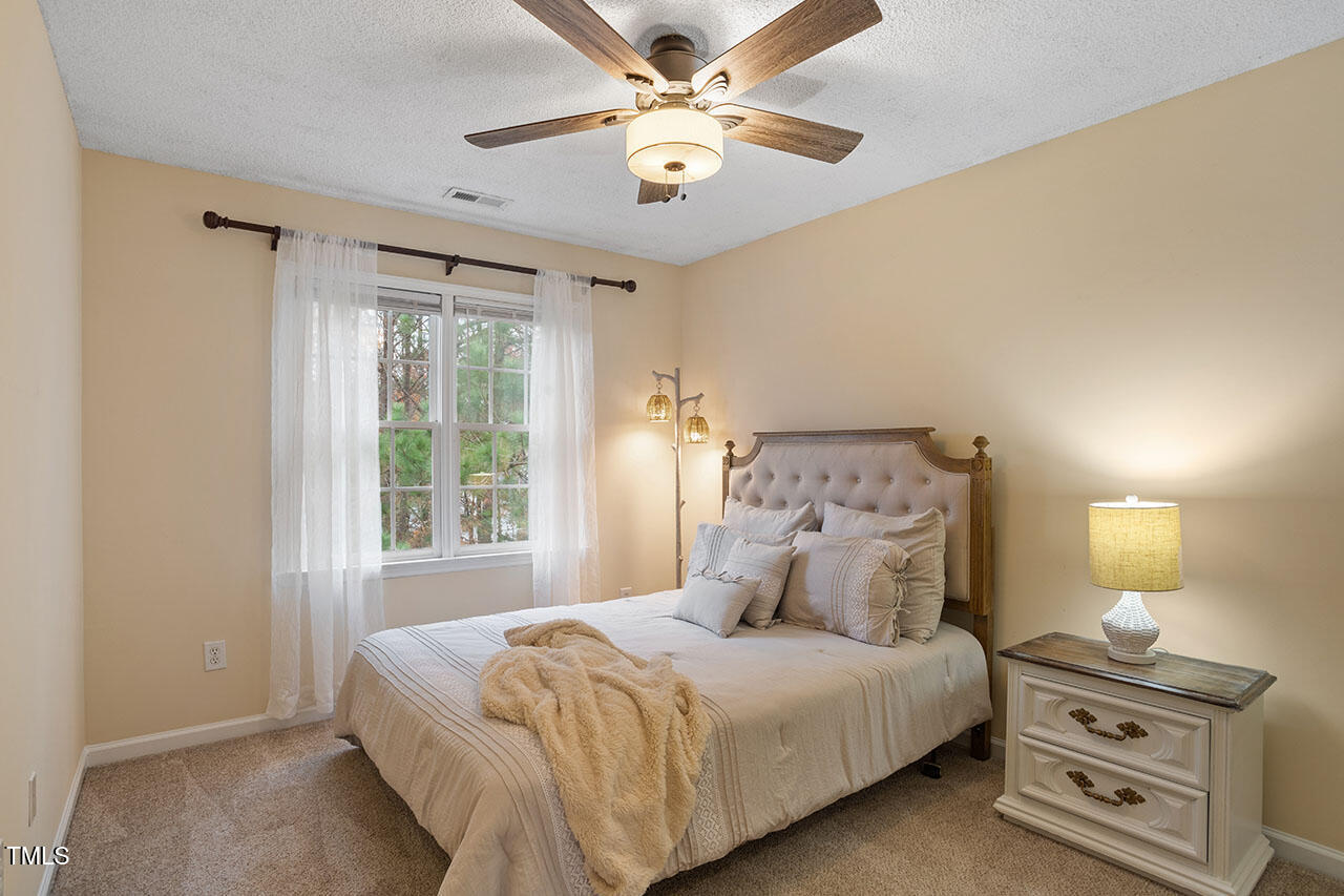 7040 Bellard Court Raleigh, NC 27617 - Photo 28 of 31 a bedroom with a bed and a ceiling fan