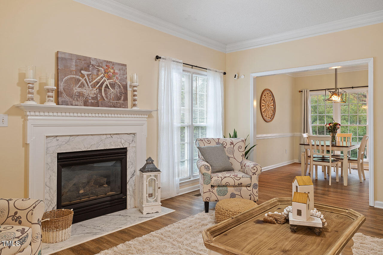 7040 Bellard Court Raleigh, NC 27617 - Photo 4 of 31 a living room with furniture a fireplace and a table