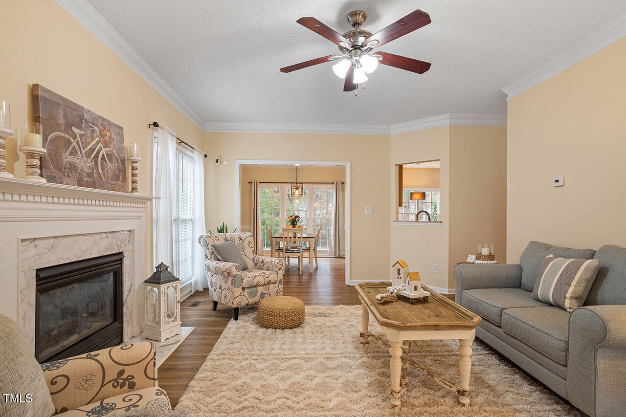 7040 Bellard Court Raleigh, NC 27617 - Photo 5 of 31 a living room with furniture a fireplace and a flat screen tv