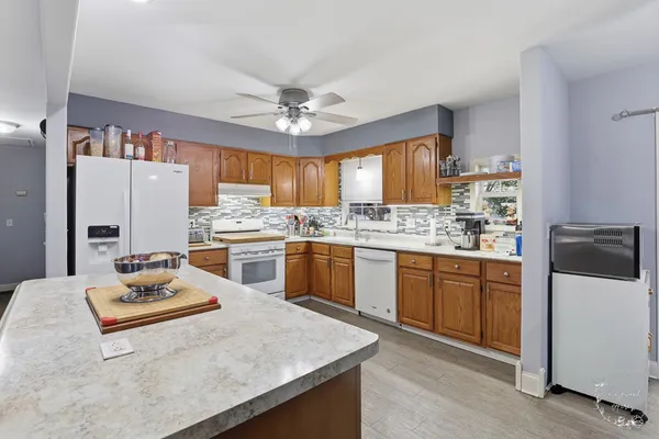 a kitchen with a refrigerator a stove a sink dishwasher and white cabinets with wooden floor
