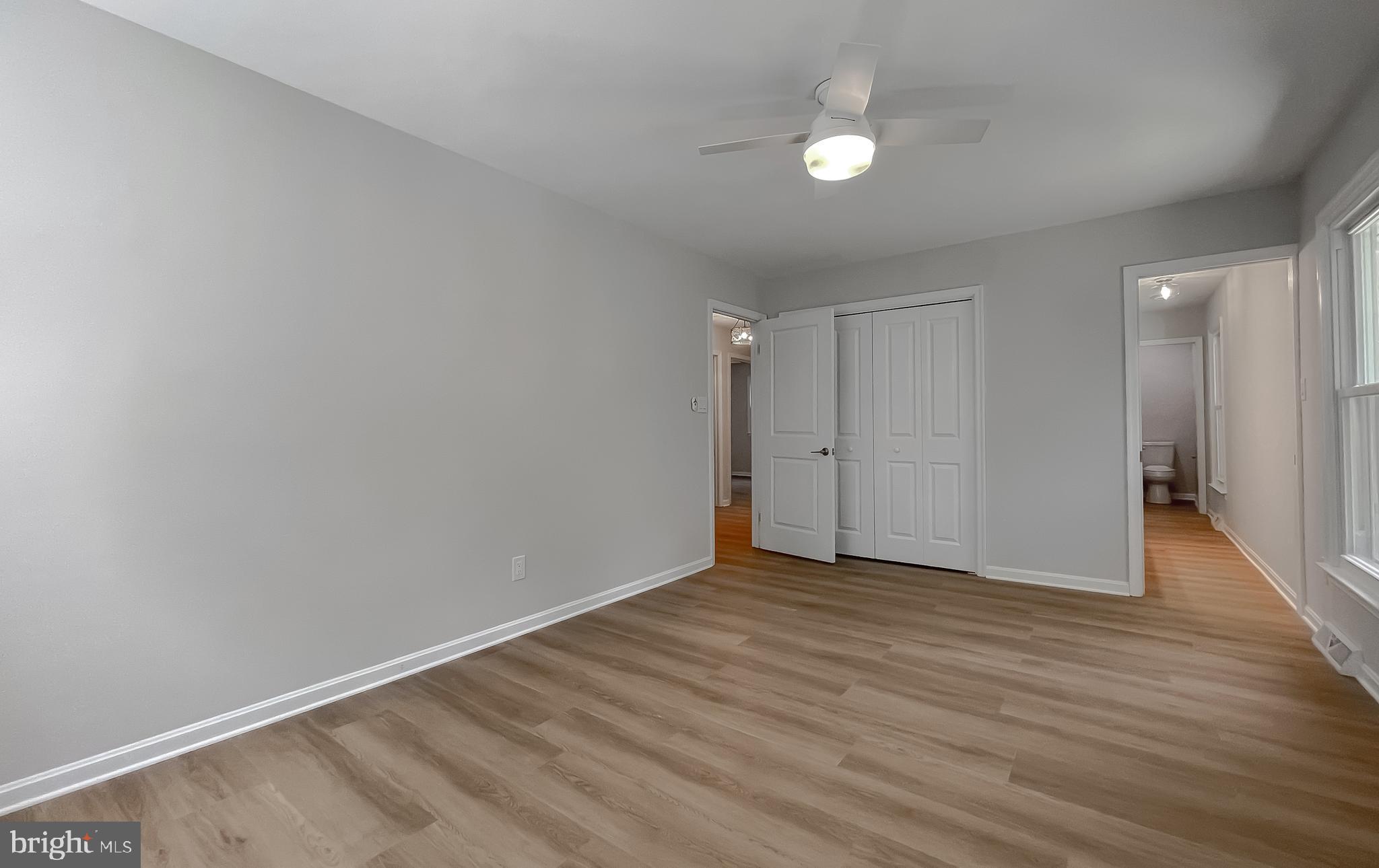 22373 Enoch Road Leonardtown, MD 20650 - Photo 39 of 74 a view of an empty room with wooden floor and a ceiling fan