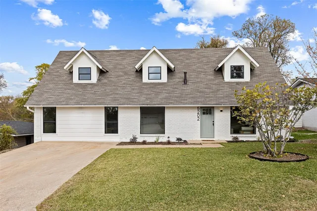 a view of a house with yard and tree s