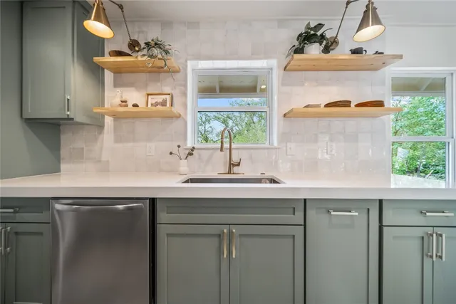 a sink with a window and cabinets