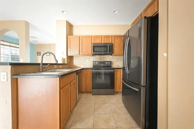 a kitchen with granite countertop a refrigerator and a sink