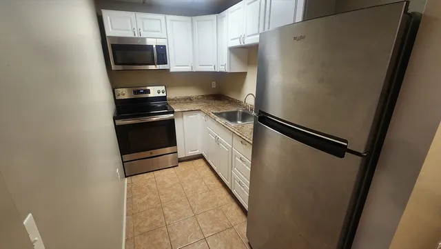 a kitchen with a refrigerator stove and microwave