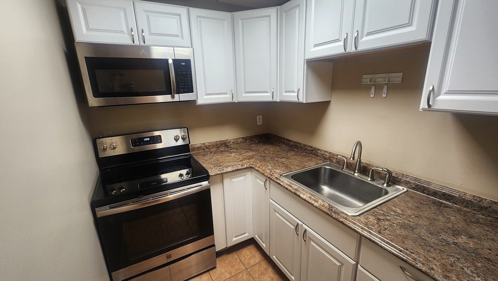 19 Washington Street, Unit 5 Haverhill, MA 01832 - Photo 3 of 17 a kitchen with a stove and a microwave