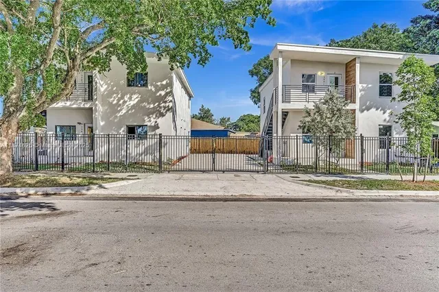 a view of a house with a yard and large tree