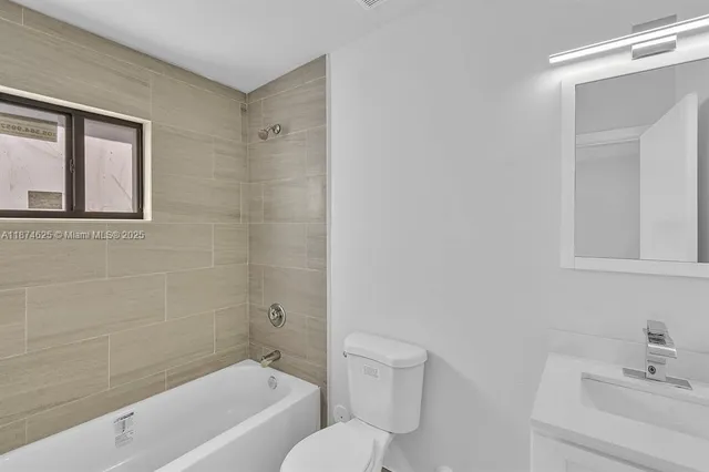 a bathroom with a toilet a sink a mirror and a bathtub