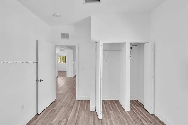 a view of a room with wooden floor and a hallway