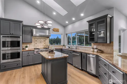 a kitchen with lots of counter top space sink and stainless steel appliances