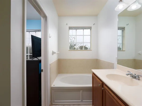 a bathroom with a tub sink and mirror