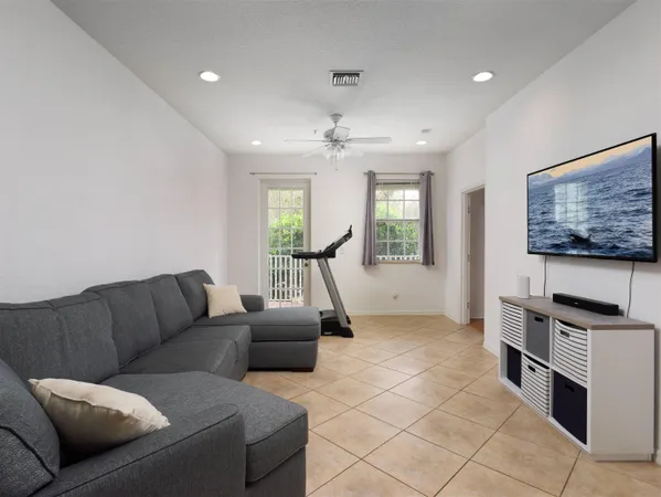 a living room with furniture a flat screen tv and a window