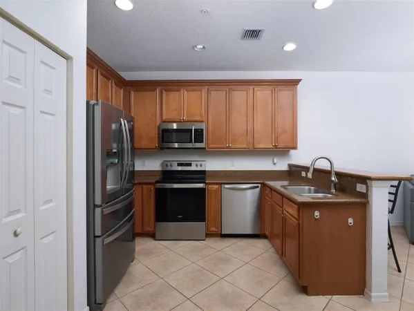 a kitchen with stainless steel appliances granite countertop a refrigerator stove and sink