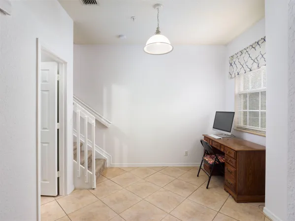 a view of a workspace with furniture and a window