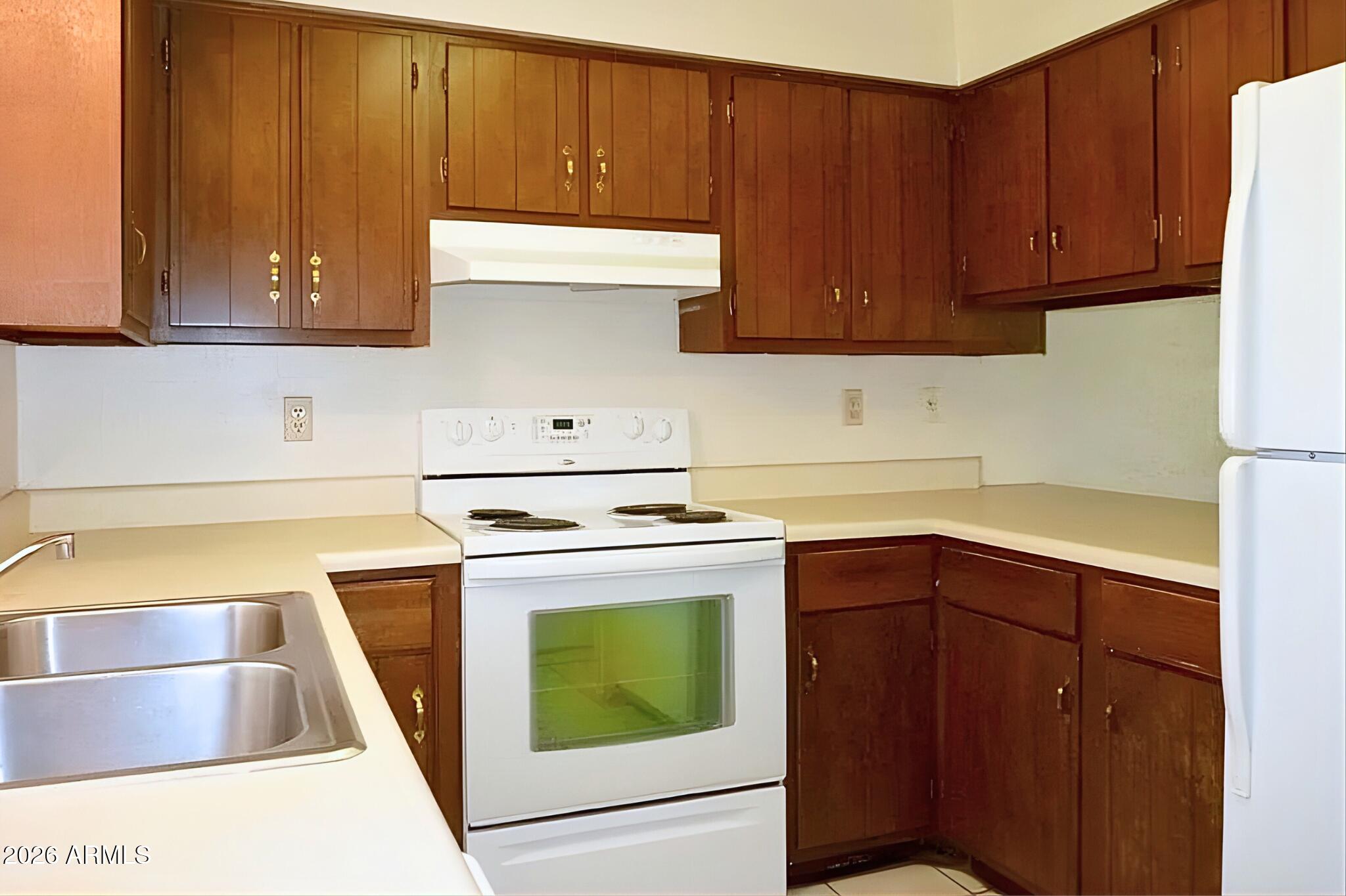 1326 North Miller Road, Unit A Tempe, AZ 85288 - Photo 3 of 6 a kitchen with a stove top oven sink and cabinets