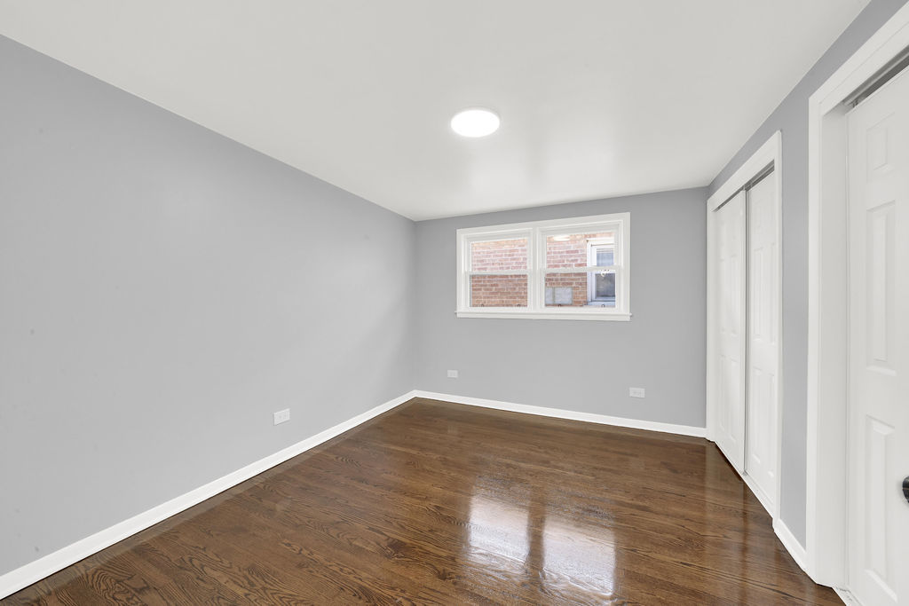 7245 South Washtenaw Avenue, Unit 1 Chicago, IL 60629 - Photo 12 of 14 an empty room with wooden floor and windows