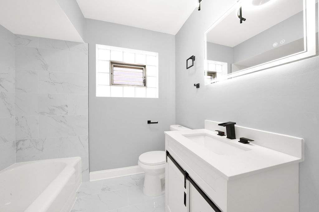 7245 South Washtenaw Avenue, Unit 1 Chicago, IL 60629 - Photo 4 of 14 a bathroom with a sink a toilet and shower