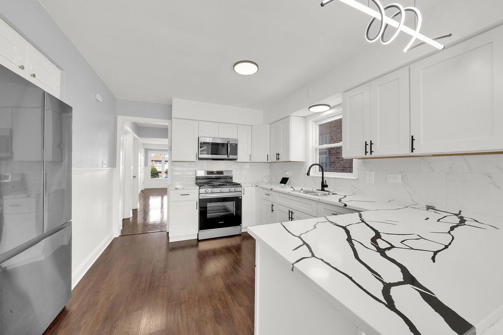 7245 South Washtenaw Avenue, Unit 1 Chicago, IL 60629 - Photo 7 of 14 a open kitchen with sink cabinets and stainless steel appliances