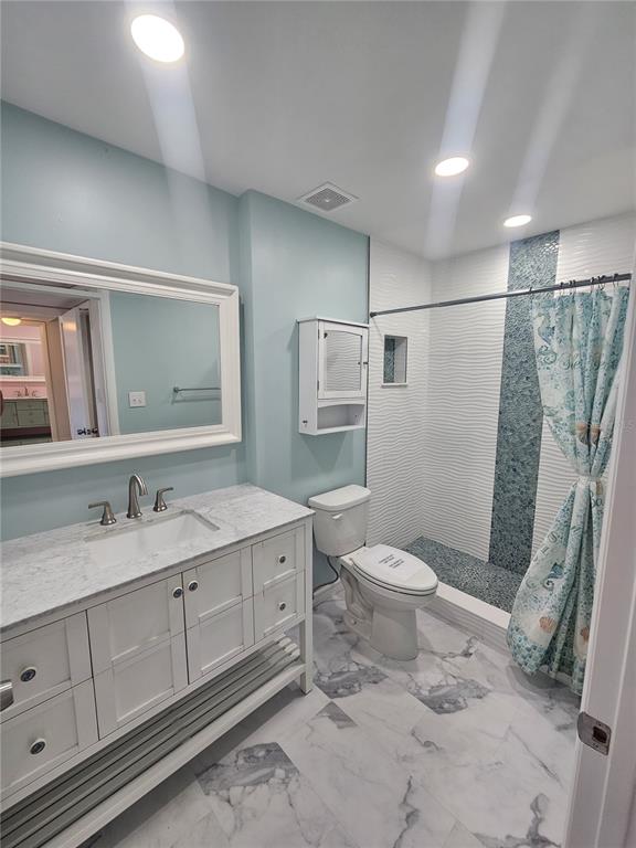 14800 Walsingham Road, Unit 1215 Largo, FL 33774 - Photo 13 of 26 a bathroom with a sink toilet and shower