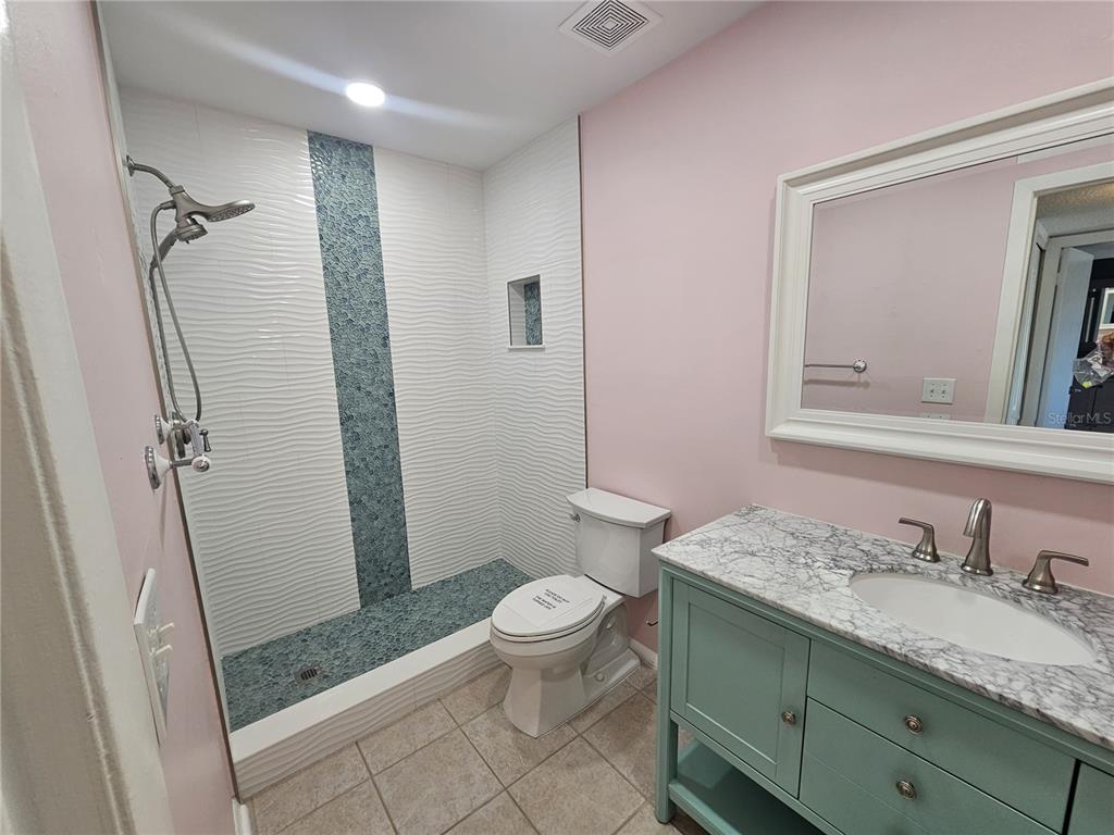 14800 Walsingham Road, Unit 1215 Largo, FL 33774 - Photo 10 of 26 a bathroom with a granite countertop sink a mirror and a toilet