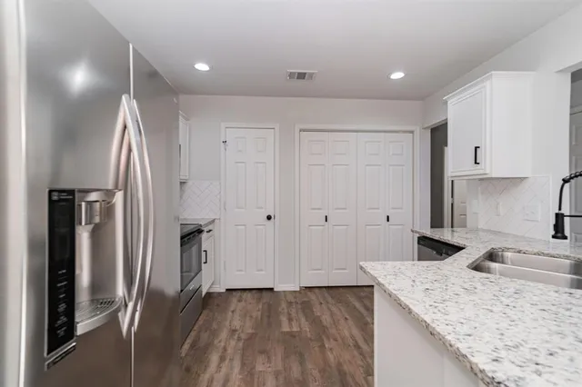 a kitchen with stainless steel appliances granite countertop a refrigerator and a sink