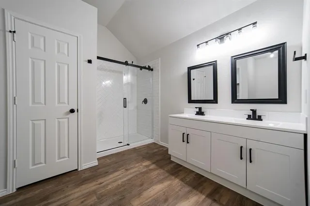 a bathroom with 2 sink mirror and shower