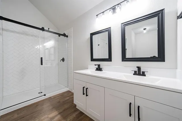 a bathroom with double vanity sinks and a mirror