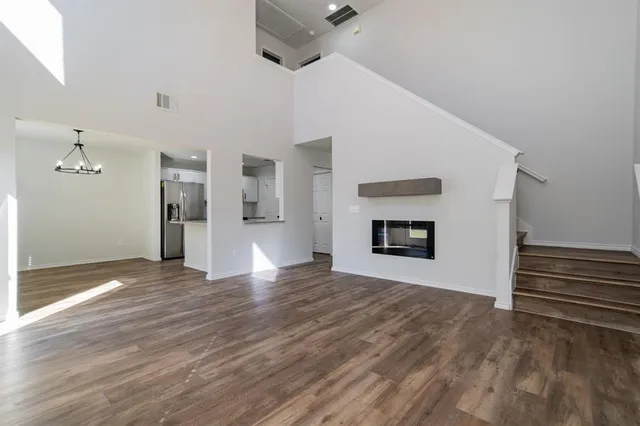 a view of an empty room with a window and a fireplace